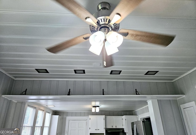 detailed view of ceiling fan, stainless steel fridge, and crown molding