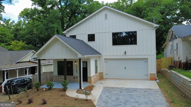 2167 Main St NW, Atlanta, GA 30318 - view of front of home featuring covered porch, an attached garage, fence, board and batten siding, and driveway
