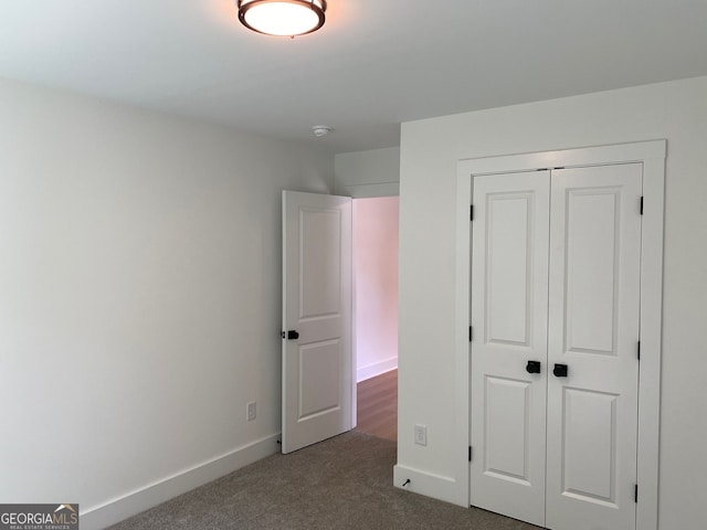 2167 Main St NW, Atlanta, GA 30318 - unfurnished bedroom with baseboards, a closet, and dark colored carpet
