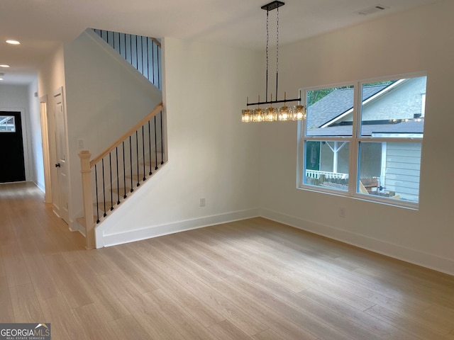 2167 Main St NW, Atlanta, GA 30318 - unfurnished dining area with an inviting chandelier, stairs, baseboards, and wood finished floors
