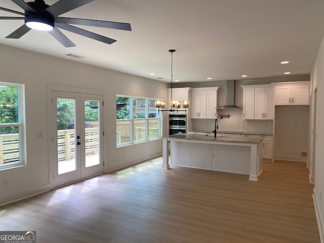 2167 Main St NW, Atlanta, GA 30318 - kitchen with wall chimney range hood, a wealth of natural light, visible vents, and white cabinetry