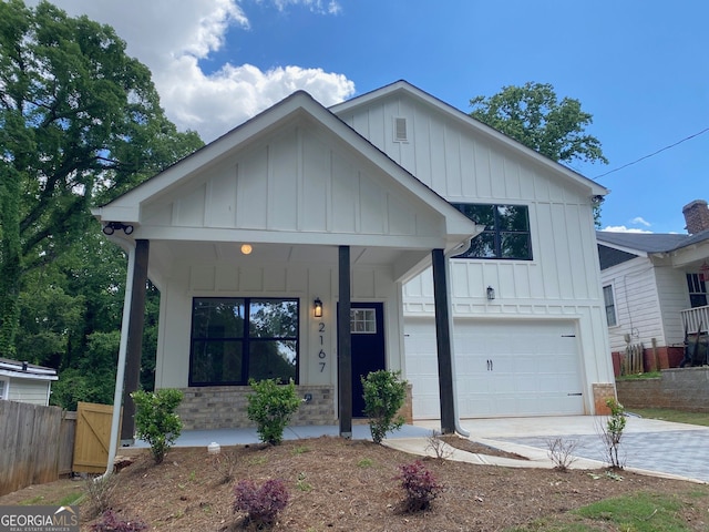 2167 Main St NW, Atlanta, GA 30318 - view of front facade with fence, an attached garage, and board and batten siding