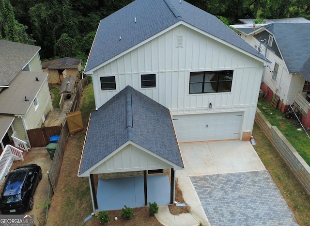 2167 Main St NW, Atlanta, GA 30318 - exterior space featuring board and batten siding, driveway, fence, an attached garage, and roof with shingles