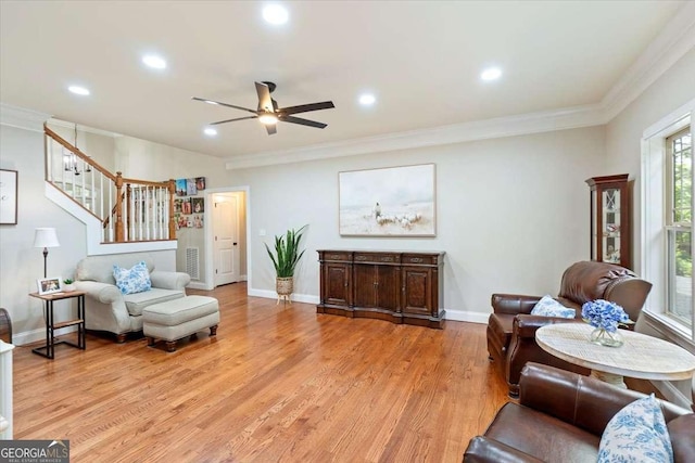 living area featuring stairs, a ceiling fan, crown molding, recessed lighting, and light wood-style flooring