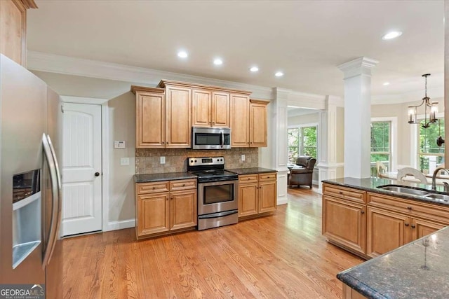 kitchen featuring appliances with stainless steel finishes, a sink, ornamental molding, light wood-style floors, and tasteful backsplash