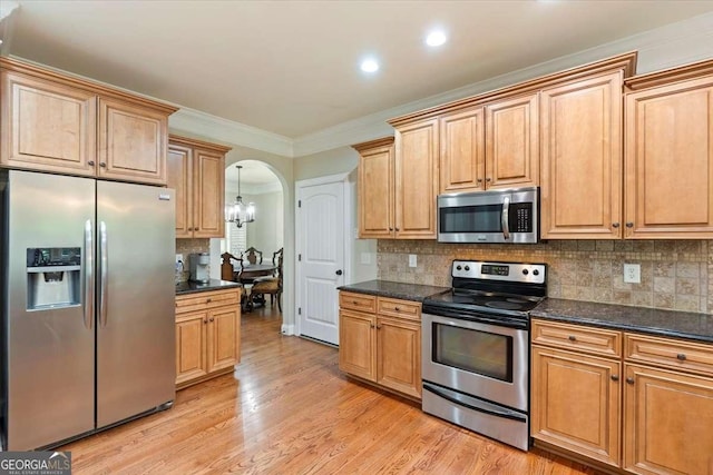 kitchen with stainless steel appliances, arched walkways, recessed lighting, tasteful backsplash, and light wood-style floors