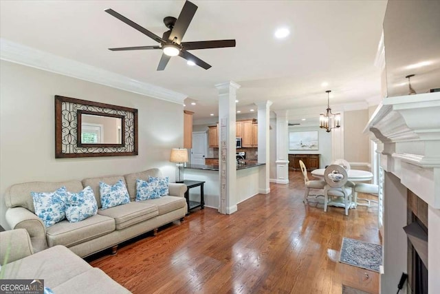 living room with a fireplace with flush hearth, ornamental molding, decorative columns, ceiling fan, and recessed lighting