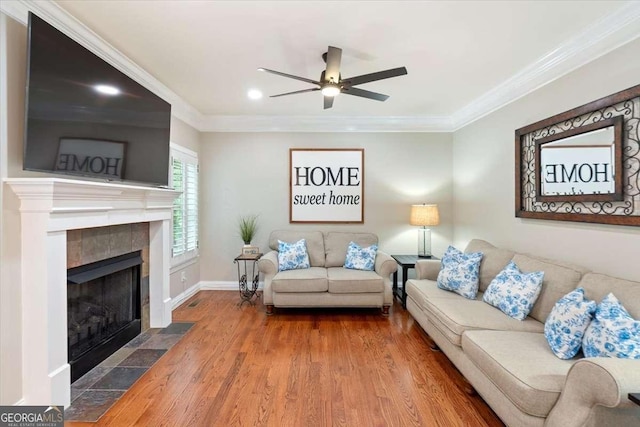 living room featuring wood finished floors, a fireplace, crown molding, ceiling fan, and recessed lighting