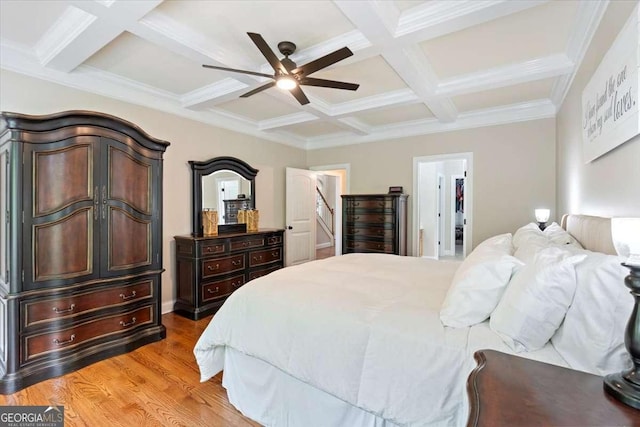 bedroom featuring coffered ceiling, beamed ceiling, light wood-type flooring, crown molding, and a ceiling fan