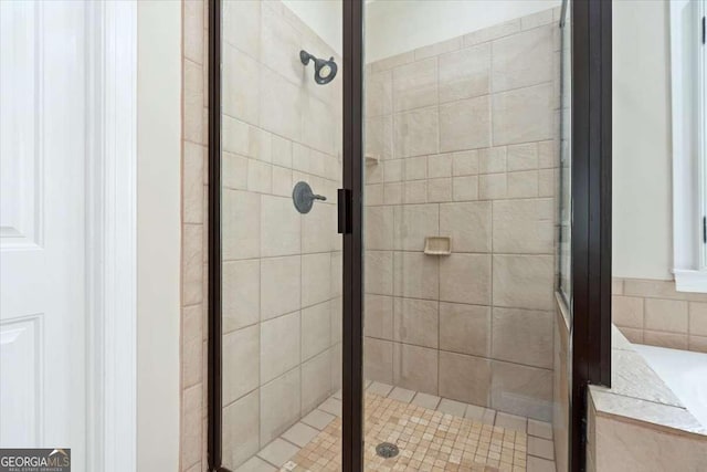 full bath with a shower stall and a tub