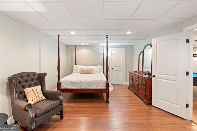 bedroom with light wood-style flooring, recessed lighting, and a paneled ceiling