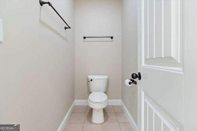 bathroom featuring toilet, baseboards, and tile patterned flooring
