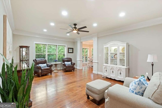 living room with ornamental molding, ceiling fan, recessed lighting, wood finished floors, and baseboards