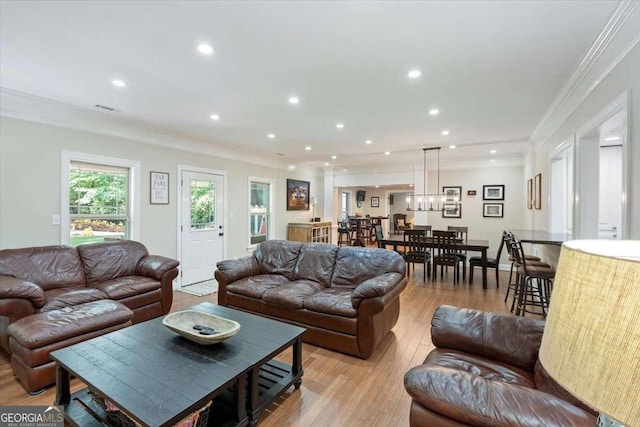 living room with crown molding, light wood-style floors, and recessed lighting