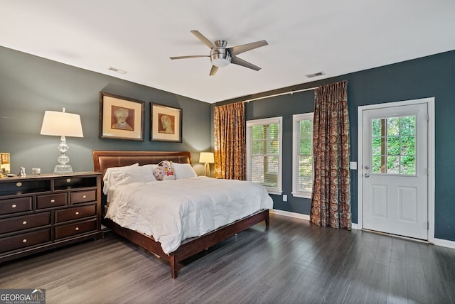 bedroom with visible vents, wood finished floors, and baseboards