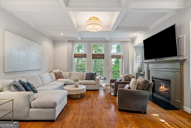 living area with coffered ceiling, beamed ceiling, a fireplace with flush hearth, and wood finished floors