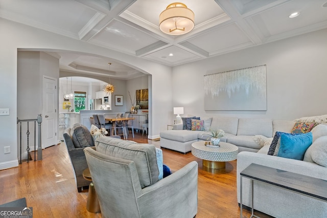 living area with wood finished floors, coffered ceiling, baseboards, beamed ceiling, and arched walkways