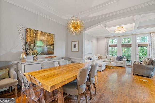 dining space featuring coffered ceiling, beam ceiling, arched walkways, light wood-style floors, and ornamental molding