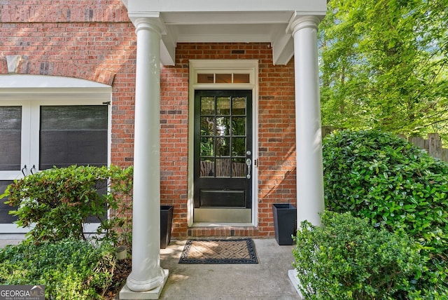 doorway to property featuring brick siding