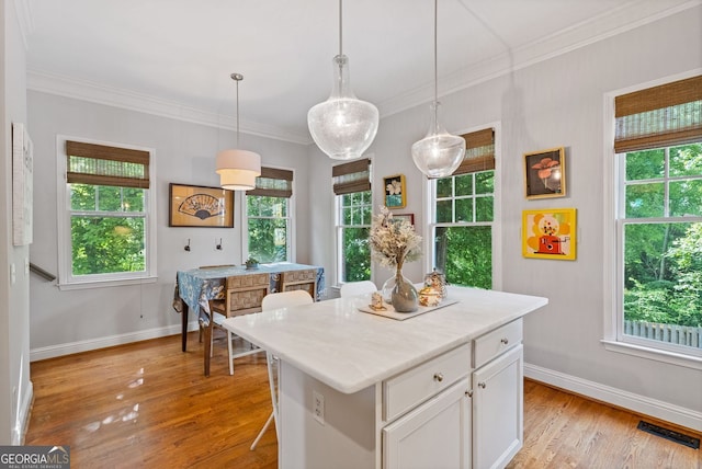 kitchen featuring a wealth of natural light, baseboards, light wood-style flooring, and white cabinetry