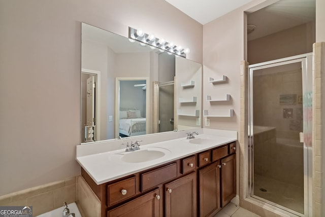 bathroom featuring a stall shower, connected bathroom, and a sink