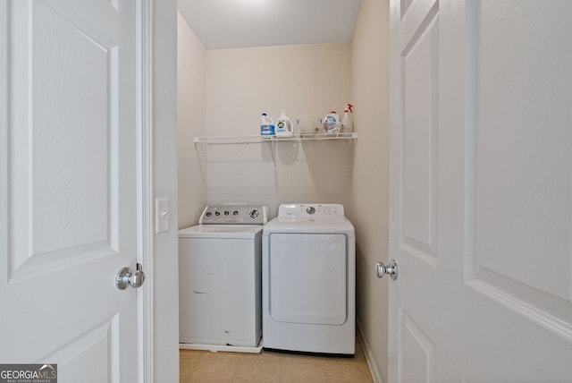 clothes washing area featuring laundry area, light tile patterned floors, and washer and dryer