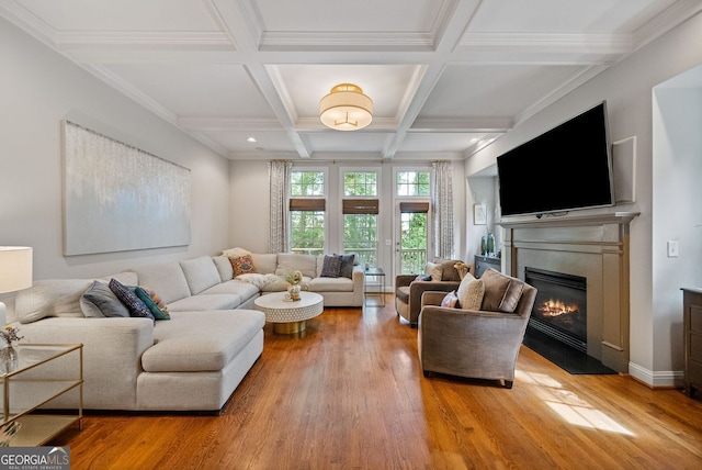 living room with light wood-type flooring, beamed ceiling, and a glass covered fireplace