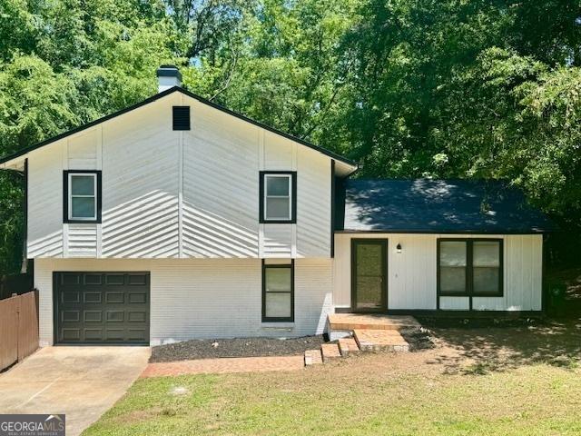 3988 Chimney Ridge Dr, Ellenwood, GA 30294 - exterior space with a chimney, driveway, brick siding, and an attached garage