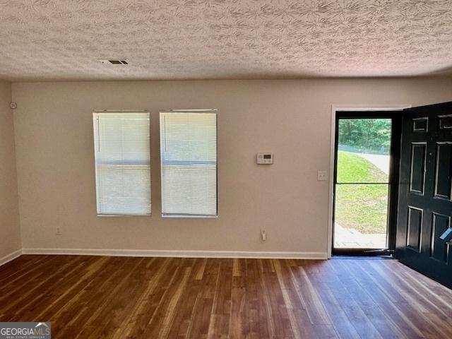 3988 Chimney Ridge Dr, Ellenwood, GA 30294 - interior space featuring a textured ceiling, visible vents, wood finished floors, and baseboards