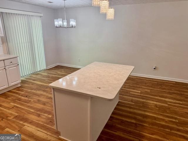 3988 Chimney Ridge Dr, Ellenwood, GA 30294 - unfurnished dining area with baseboards, a notable chandelier, and wood finished floors