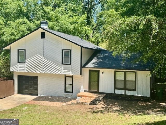 3988 Chimney Ridge Dr, Ellenwood, GA 30294 - view of front of property featuring fence, driveway, a chimney, and a garage