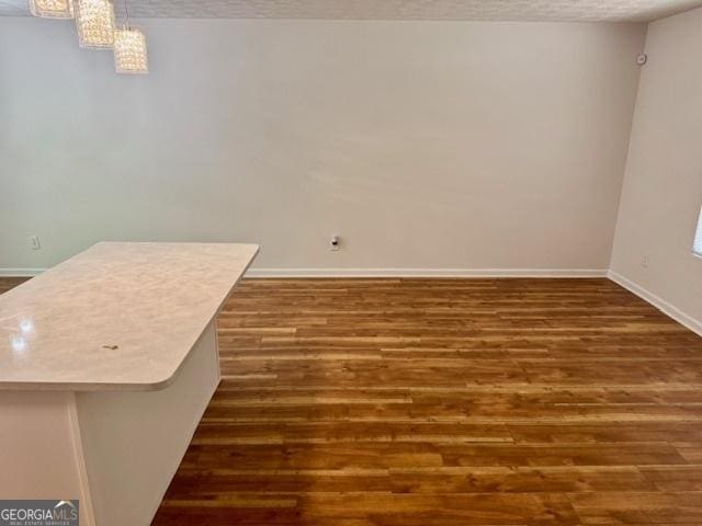 3988 Chimney Ridge Dr, Ellenwood, GA 30294 - unfurnished dining area featuring a textured ceiling, dark wood-type flooring, and baseboards