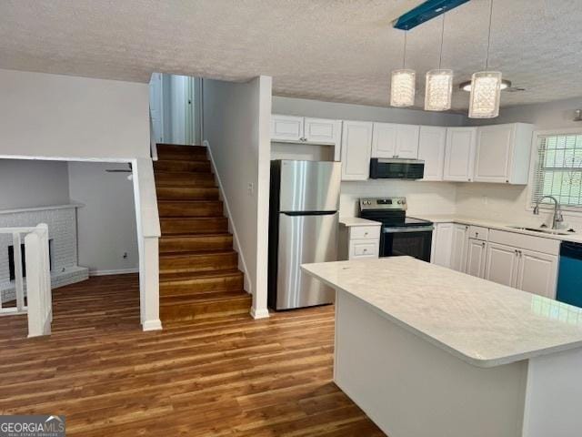 3988 Chimney Ridge Dr, Ellenwood, GA 30294 - kitchen with a sink, a textured ceiling, light countertops, appliances with stainless steel finishes, and dark wood-style floors