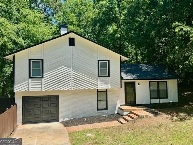3988 Chimney Ridge Dr, Ellenwood, GA 30294 - view of front facade featuring a chimney, brick siding, a garage, and concrete driveway