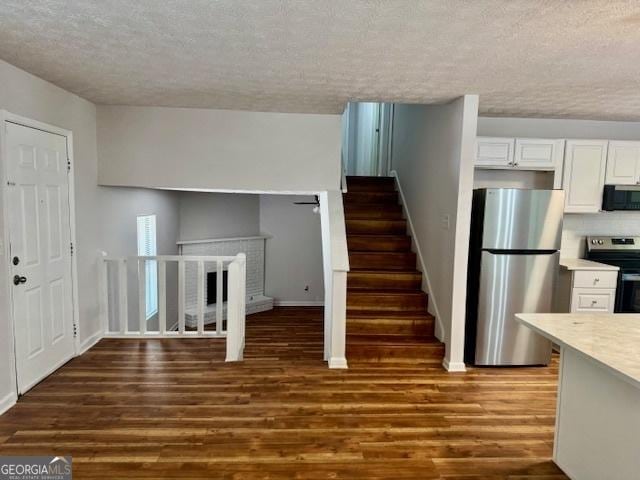 3988 Chimney Ridge Dr, Ellenwood, GA 30294 - stairway with a textured ceiling, baseboards, and wood finished floors
