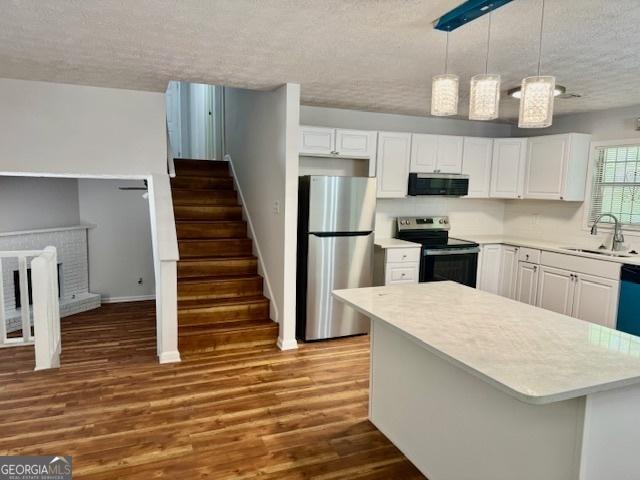 3988 Chimney Ridge Dr, Ellenwood, GA 30294 - kitchen with a sink, a textured ceiling, light countertops, and appliances with stainless steel finishes