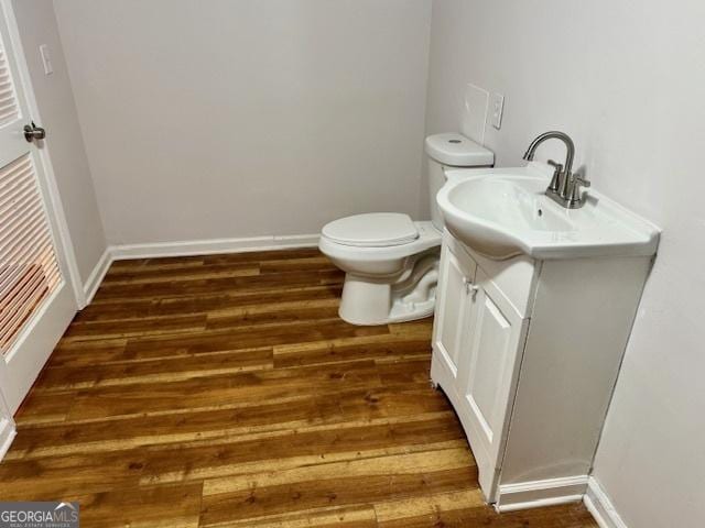 3988 Chimney Ridge Dr, Ellenwood, GA 30294 - bathroom featuring toilet, baseboards, wood finished floors, and vanity