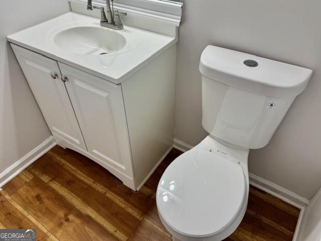3988 Chimney Ridge Dr, Ellenwood, GA 30294 - bathroom with vanity, toilet, baseboards, and wood finished floors