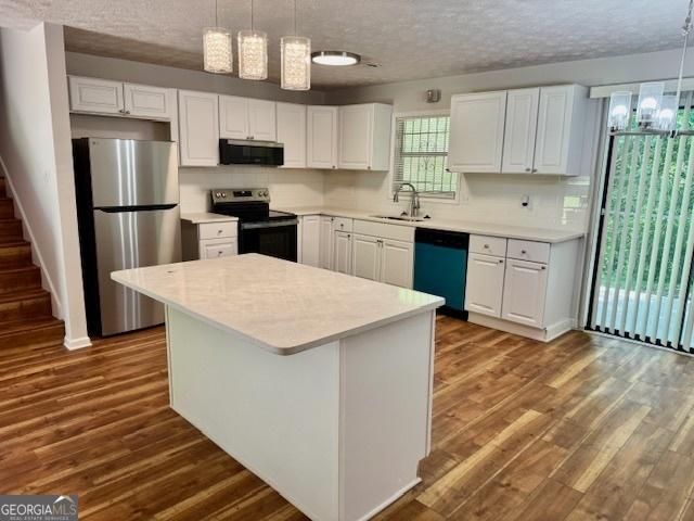 3988 Chimney Ridge Dr, Ellenwood, GA 30294 - kitchen with a sink, a textured ceiling, white cabinetry, light countertops, and appliances with stainless steel finishes