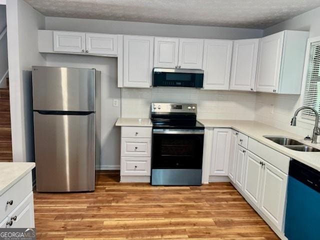 3988 Chimney Ridge Dr, Ellenwood, GA 30294 - kitchen with stainless steel appliances, a sink, backsplash, light countertops, and white cabinets