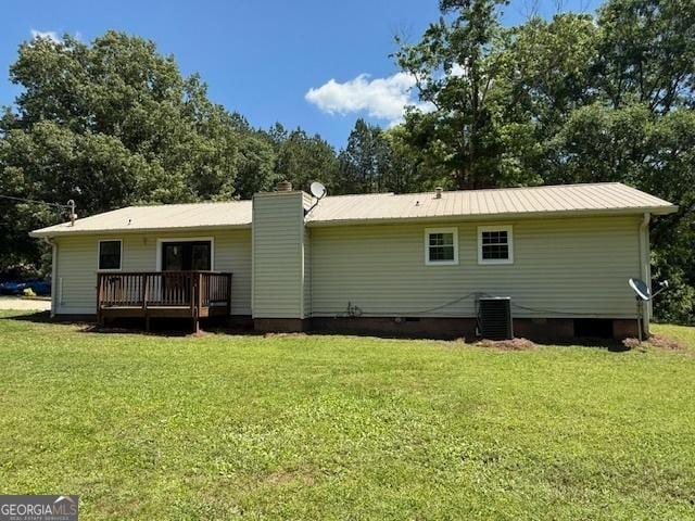 back of house featuring a yard, a deck, cooling unit, and a chimney