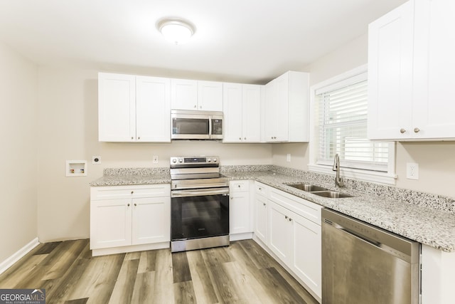 338 Mount Zion Rd, Hapeville, GA 30354 - kitchen with a sink, stainless steel appliances, light stone counters, white cabinets, and light wood-style floors