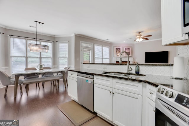 kitchen with ornamental molding, white appliances, a sink, and wood finished floors