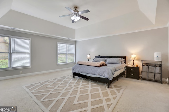 bedroom featuring a tray ceiling, light carpet, baseboards, and visible vents