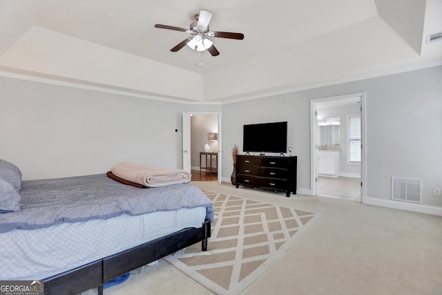 carpeted bedroom with baseboards, a raised ceiling, visible vents, and a ceiling fan