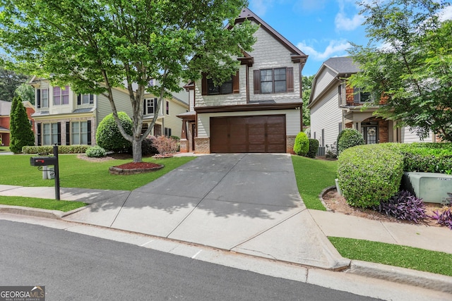 view of front of house with concrete driveway, a front lawn, brick siding, and a garage