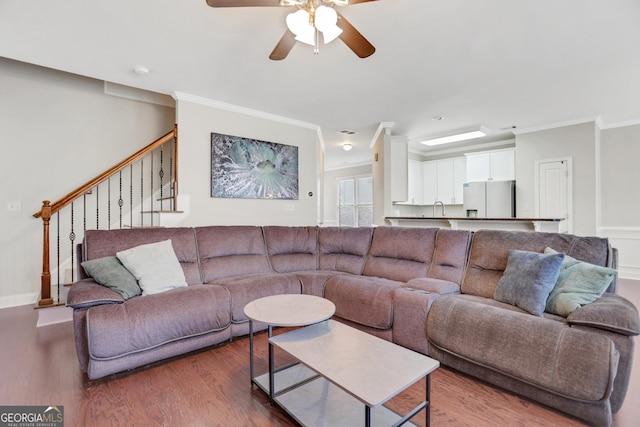 living room with ceiling fan, stairway, crown molding, and wood finished floors
