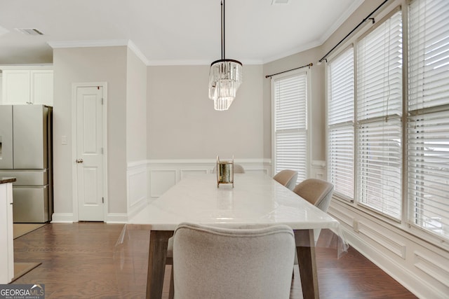 unfurnished dining area featuring dark wood-style flooring, visible vents, a chandelier, and crown molding