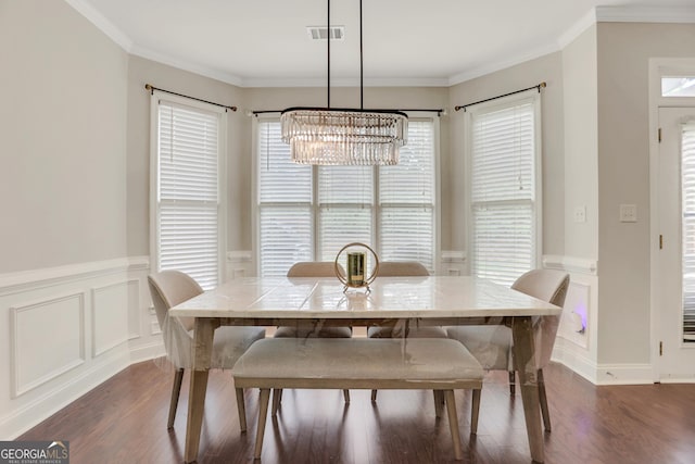 dining space featuring dark wood-style flooring, a chandelier, visible vents, and a wainscoted wall