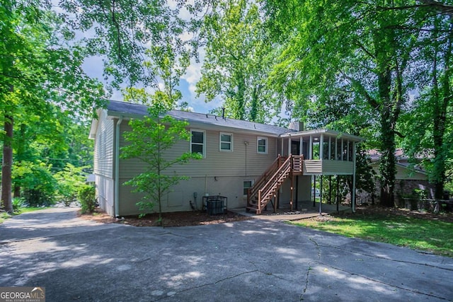 3938 Emerald Springs Ct, Decatur, GA 30035 - rear view of house featuring aphalt driveway, a sunroom, stairs, and a patio